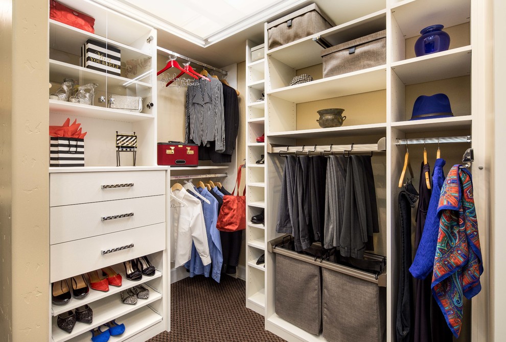 This is an example of a medium sized contemporary gender neutral walk-in wardrobe in San Francisco with glass-front cabinets, white cabinets and carpet.