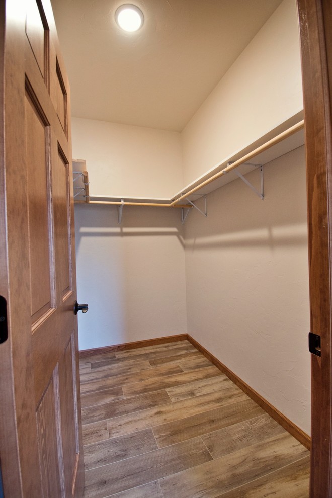 Idéer för ett stort lantligt walk-in-closet för könsneutrala, med mellanmörkt trägolv och brunt golv