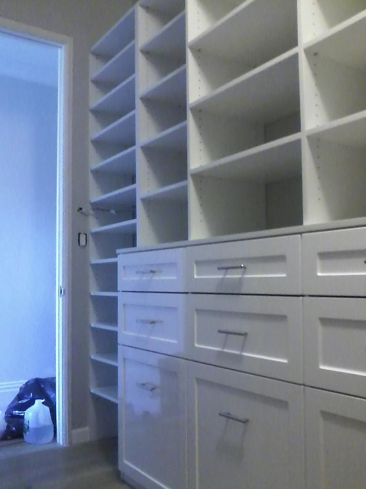 Imagen de armario vestidor unisex contemporáneo pequeño con armarios estilo shaker, puertas de armario blancas y suelo de madera clara