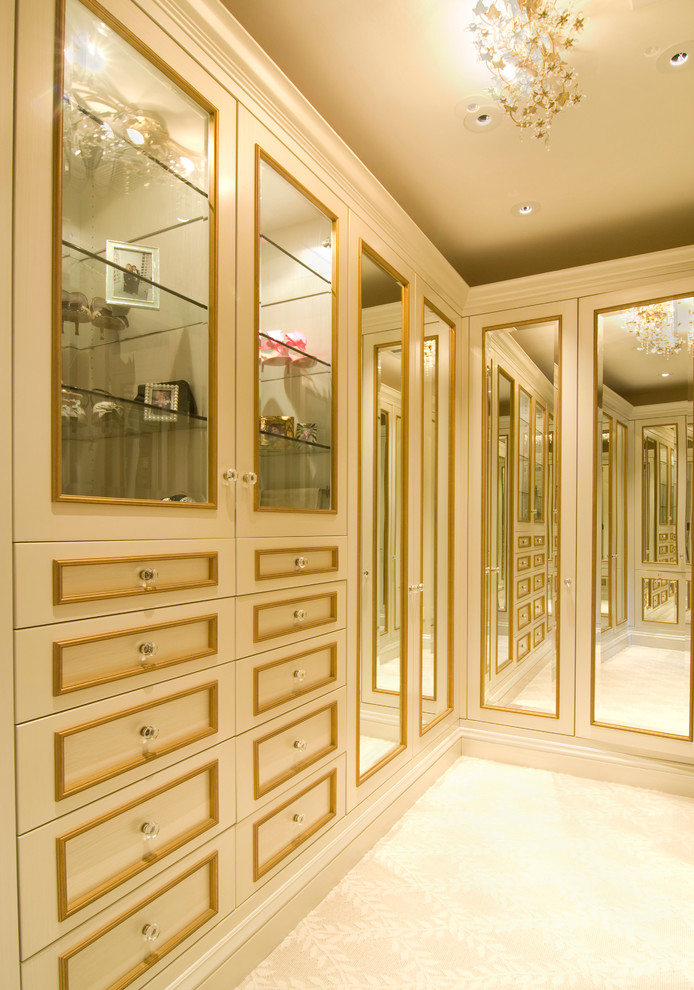 Exemple d'un grand dressing room chic pour une femme avec des portes de placard beiges, moquette et un sol beige.