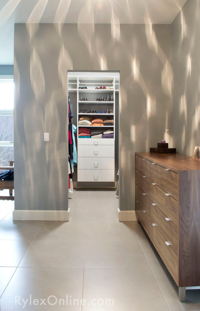 Walk-in closet - small 1960s gender-neutral walk-in closet idea in New York with flat-panel cabinets and white cabinets
