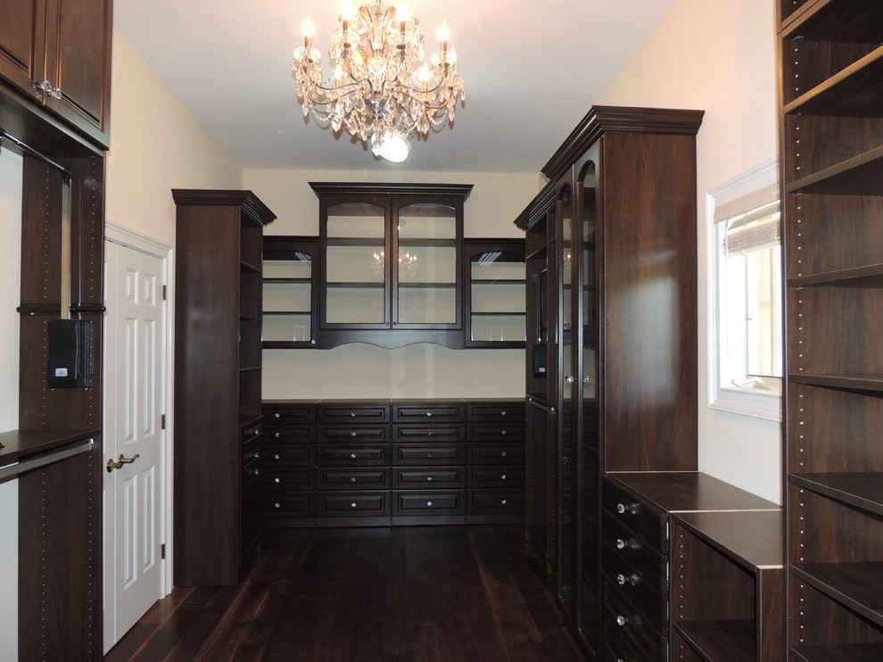Large elegant gender-neutral dark wood floor walk-in closet photo in Philadelphia with raised-panel cabinets and brown cabinets