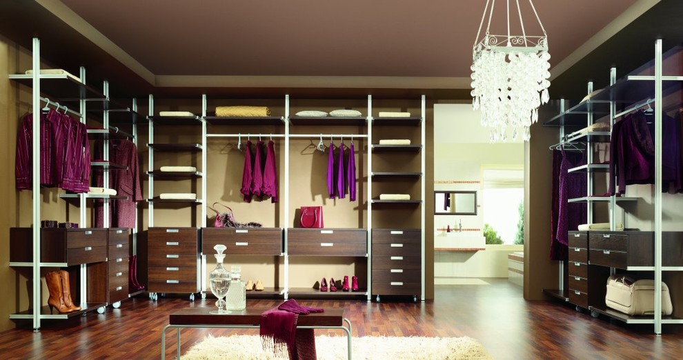 Foto de armario vestidor minimalista grande con puertas de armario de madera en tonos medios, suelo de madera oscura y armarios con paneles lisos