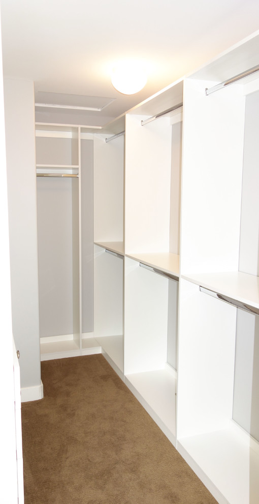 Walk-in closet - contemporary walk-in closet idea in Vancouver with flat-panel cabinets and white cabinets