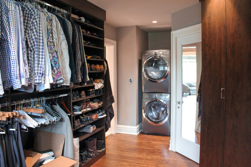 Huge transitional men's medium tone wood floor walk-in closet photo in Other with flat-panel cabinets and brown cabinets