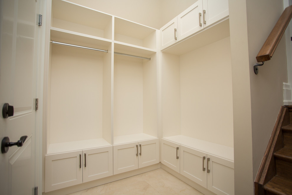 Cette image montre un grand dressing room traditionnel neutre avec des portes de placard blanches, parquet foncé et un placard avec porte à panneau encastré.