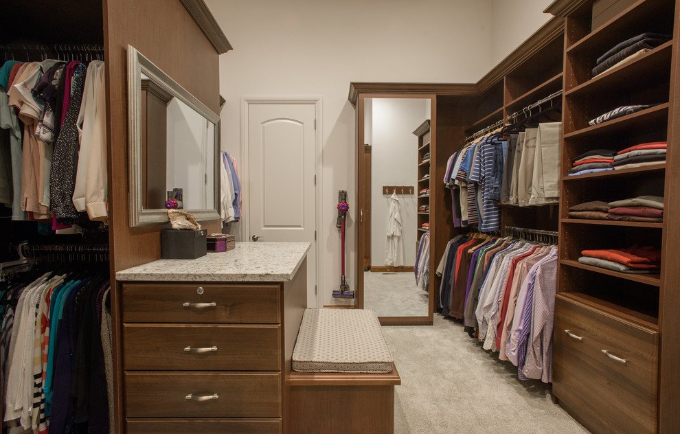 Large classic gender neutral walk-in wardrobe in Denver with flat-panel cabinets, medium wood cabinets, carpet and white floors.