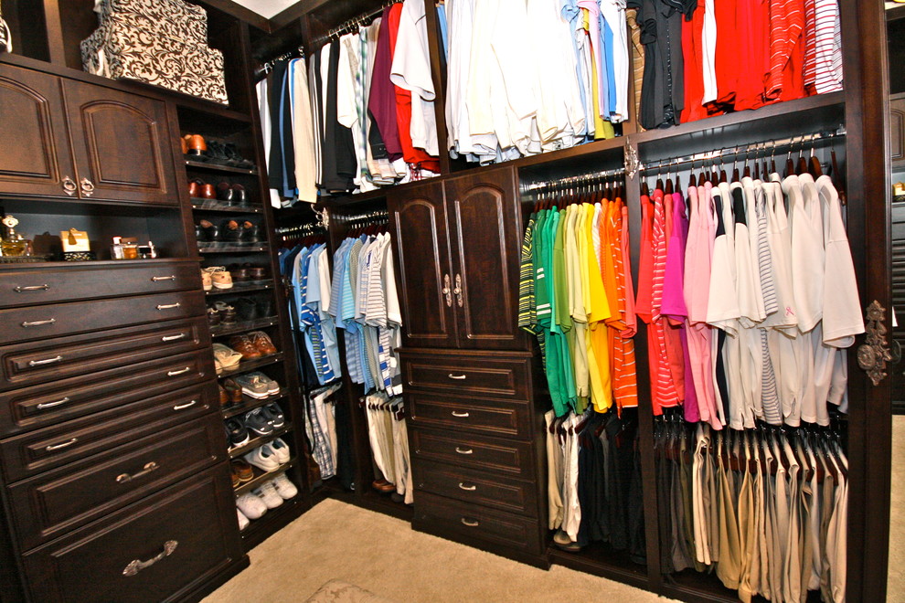 Example of a mid-sized transitional gender-neutral walk-in closet design in Los Angeles with medium tone wood cabinets and recessed-panel cabinets