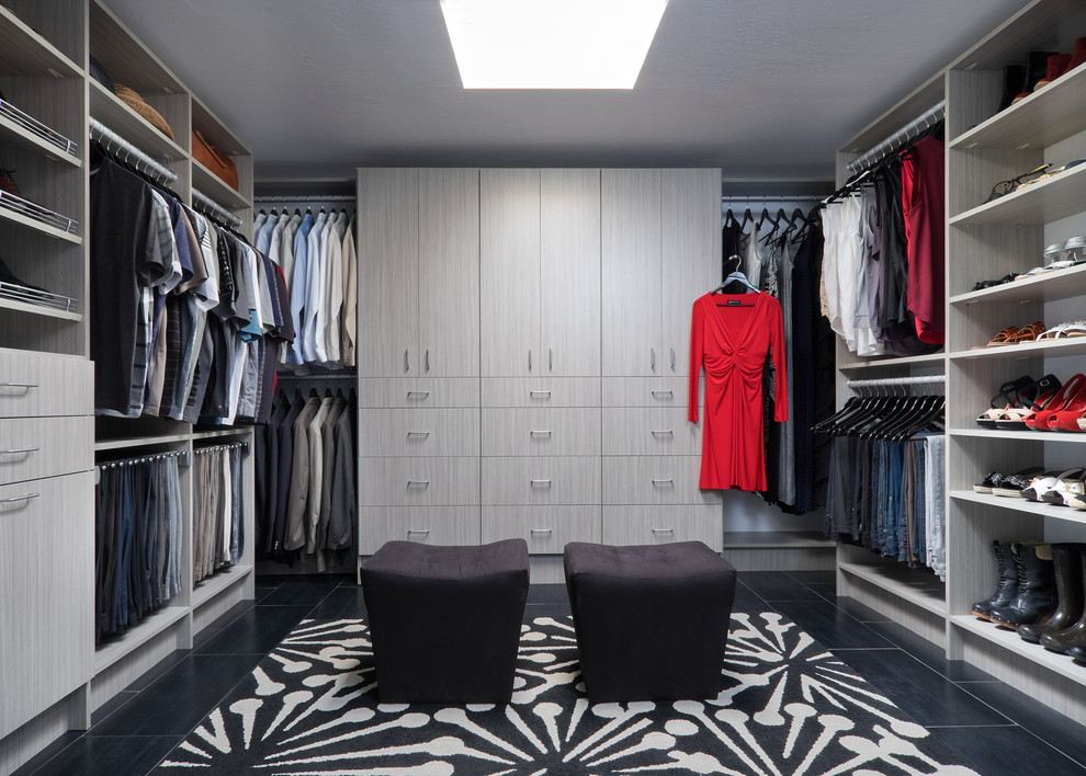 Ejemplo de armario vestidor unisex moderno grande con armarios con paneles lisos, puertas de armario de madera clara, suelo de baldosas de porcelana y suelo negro