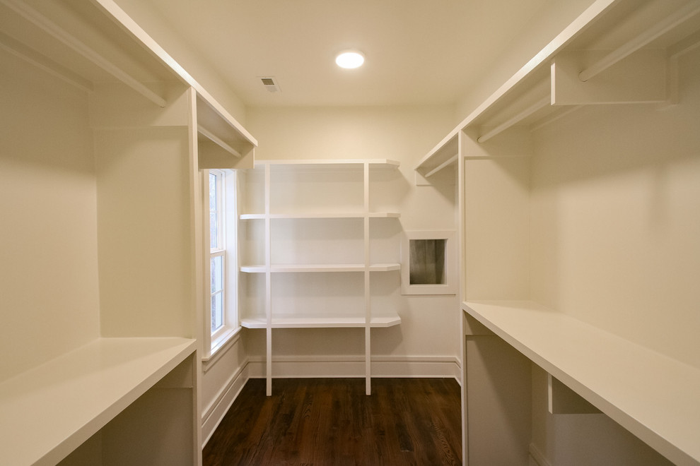 Example of a mid-sized arts and crafts medium tone wood floor and brown floor walk-in closet design in Charlotte