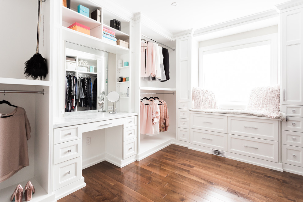 Elegant medium tone wood floor and brown floor dressing room photo in Other with recessed-panel cabinets and white cabinets