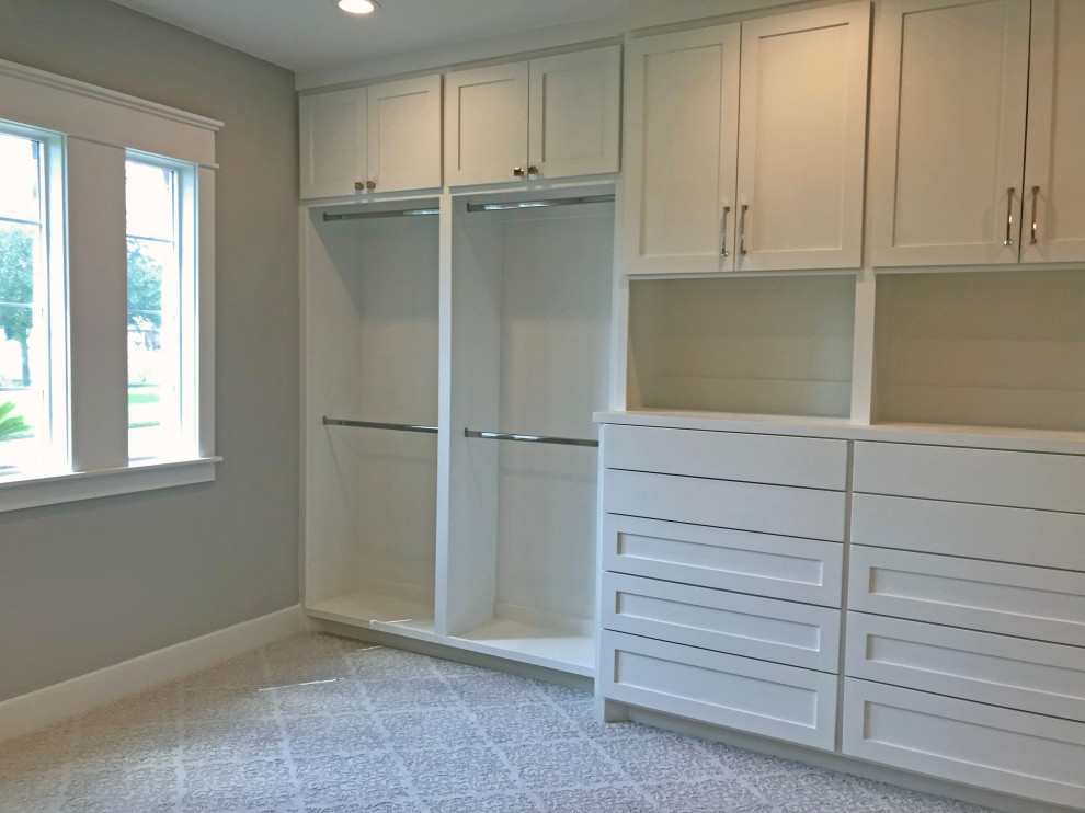 Inspiration for a mid-sized country gender-neutral walk-in wardrobe in Houston with shaker cabinets, white cabinets, carpet and white floor.