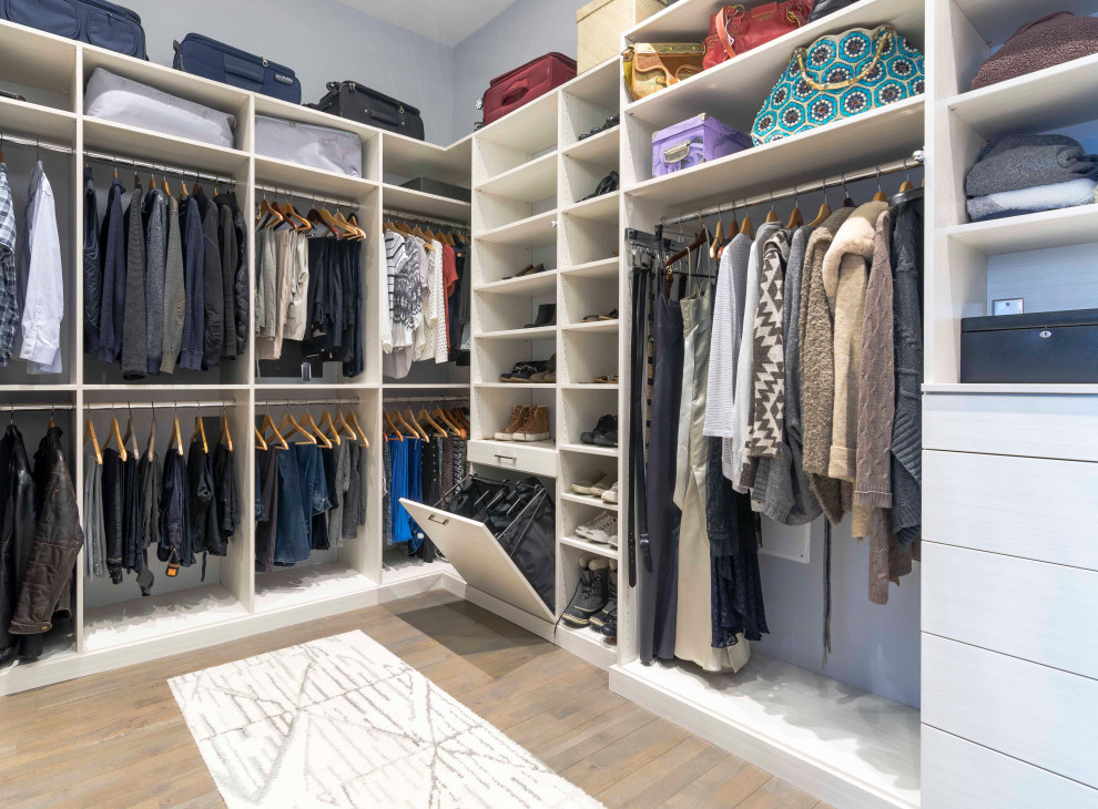 Inspiration for a large contemporary gender-neutral light wood floor and brown floor walk-in closet remodel in New York with flat-panel cabinets and light wood cabinets