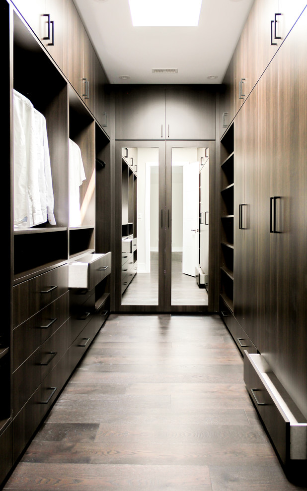 Imagen de armario vestidor unisex actual de tamaño medio con armarios con paneles lisos, puertas de armario de madera en tonos medios, suelo de madera clara y suelo marrón