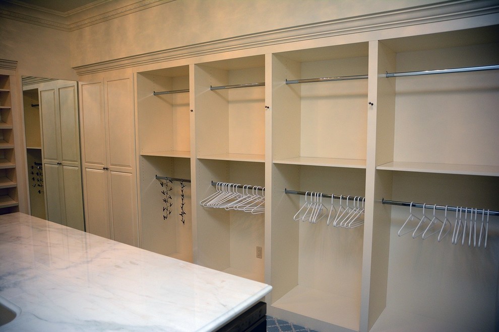 Ejemplo de armario vestidor de mujer actual grande con armarios abiertos, puertas de armario beige y moqueta