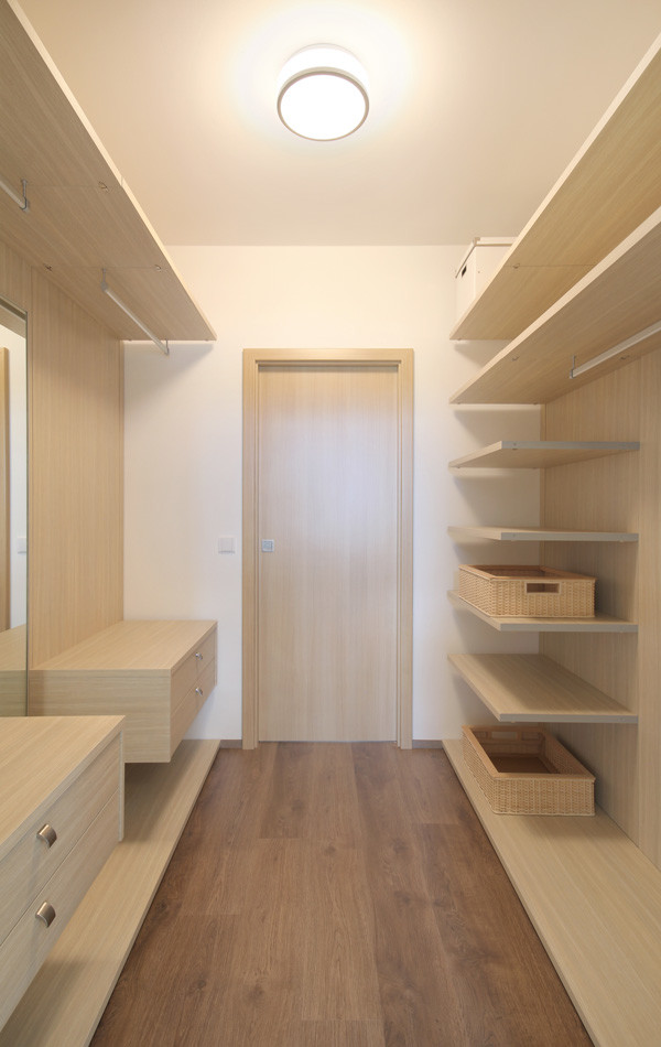 Inspiration pour un grand dressing room minimaliste en bois clair avec un placard sans porte et un sol en bois brun.