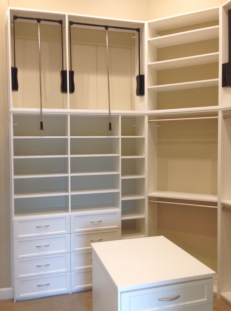 Ejemplo de armario vestidor unisex clásico renovado grande con armarios con paneles con relieve, puertas de armario blancas, moqueta y suelo beige