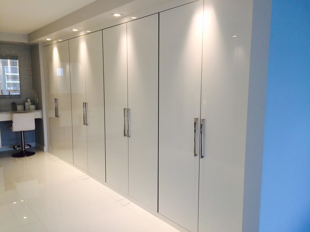 Large contemporary gender neutral standard wardrobe in Miami with flat-panel cabinets, white cabinets, porcelain flooring and beige floors.