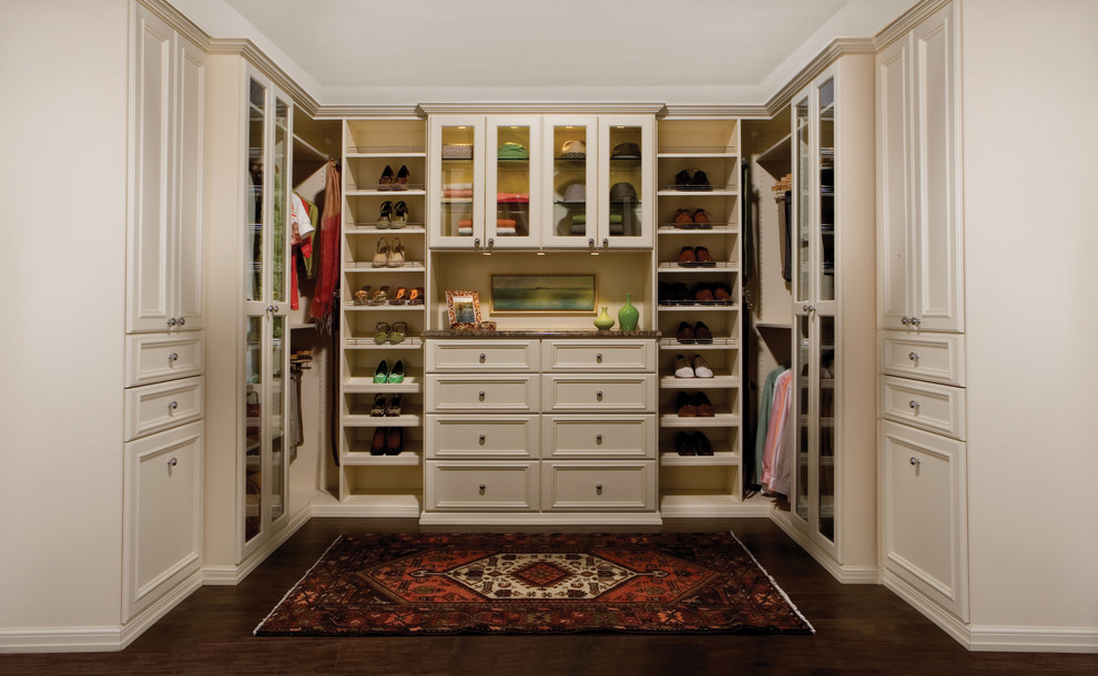 Ejemplo de vestidor unisex clásico grande con armarios con paneles empotrados, puertas de armario blancas y suelo de madera oscura