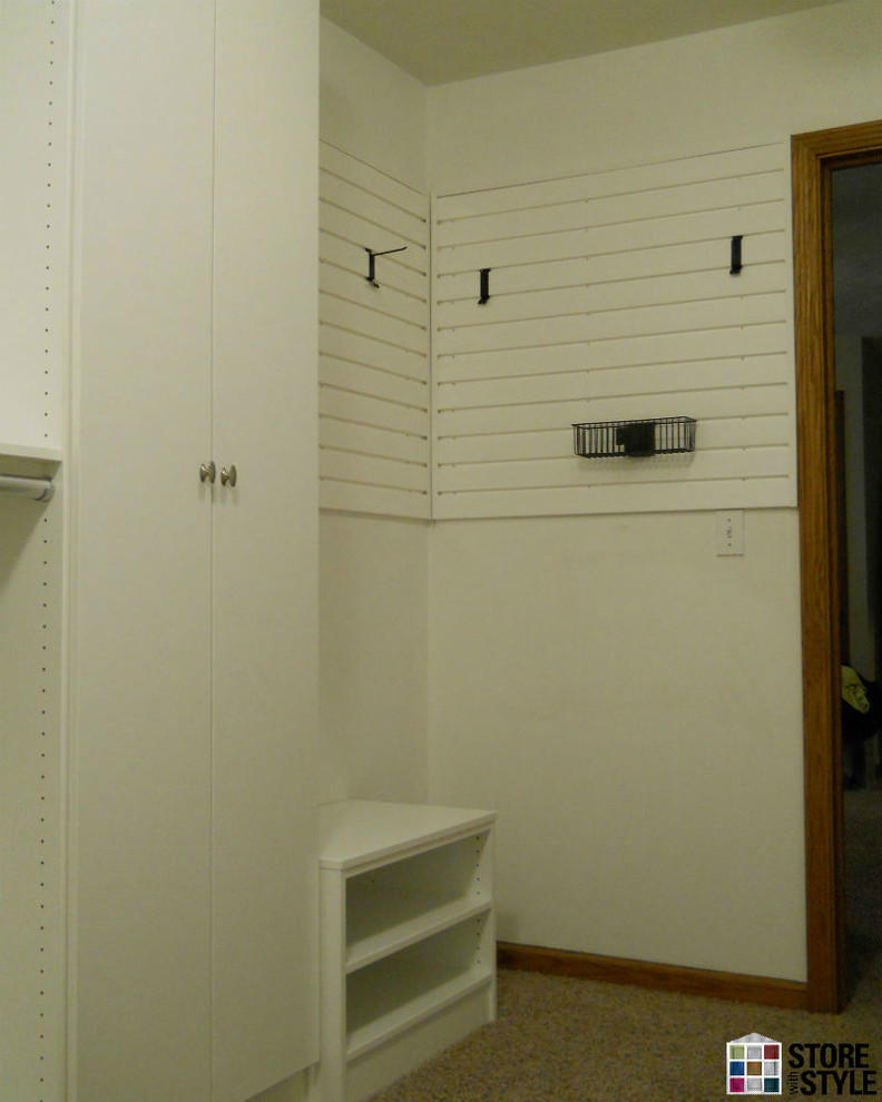 Esempio di un'ampia cabina armadio unisex minimalista con ante lisce, ante bianche e moquette