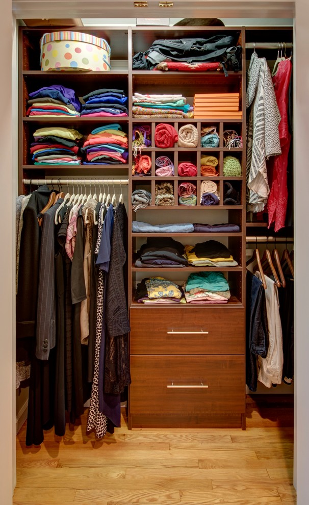 Reach-in closet - small transitional gender-neutral medium tone wood floor and beige floor reach-in closet idea in New York with flat-panel cabinets and dark wood cabinets