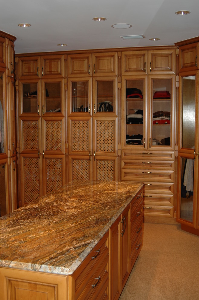 Imagen de armario vestidor unisex rústico de tamaño medio con armarios con paneles con relieve, puertas de armario de madera en tonos medios, moqueta y suelo beige