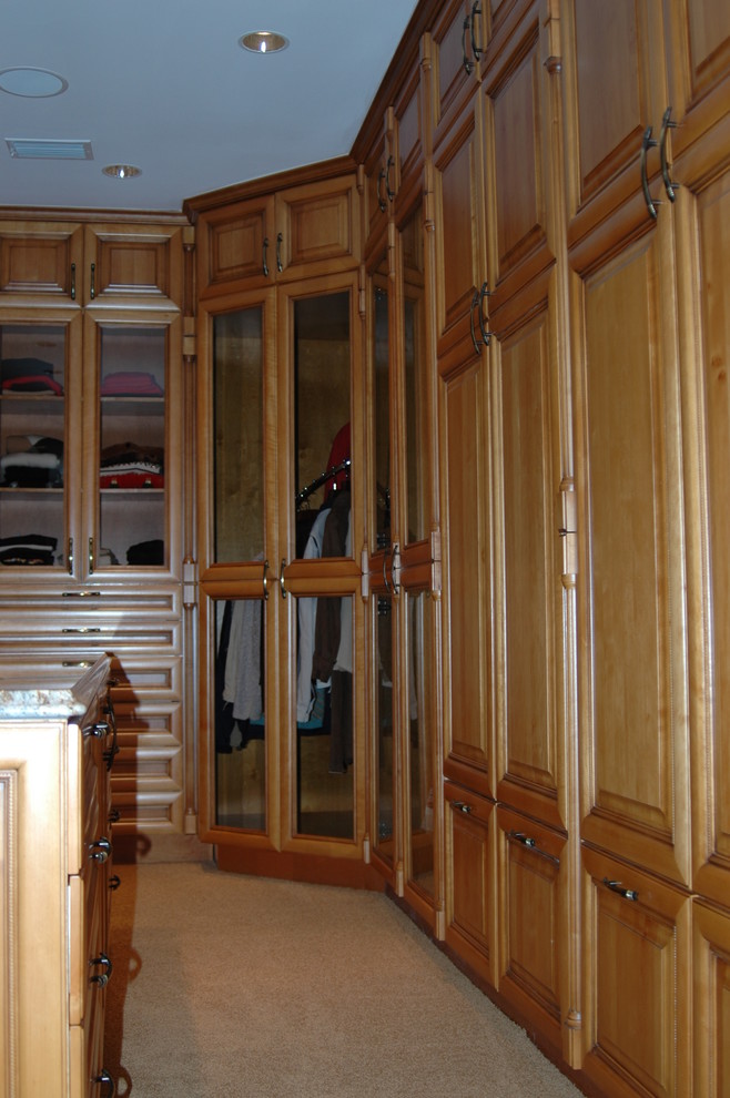 Ejemplo de armario vestidor unisex rústico de tamaño medio con armarios con paneles con relieve, puertas de armario de madera en tonos medios, moqueta y suelo beige