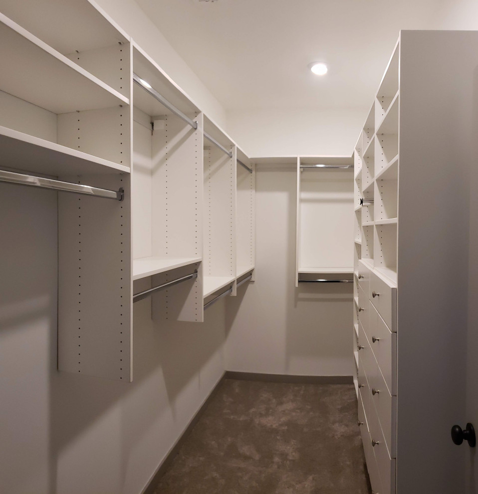 Foto di una cabina armadio unisex minimalista di medie dimensioni con ante lisce, ante bianche, moquette e pavimento beige
