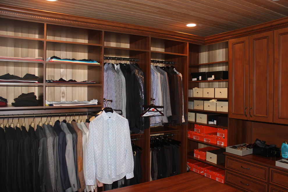 Diseño de vestidor unisex moderno de tamaño medio con armarios abiertos, puertas de armario con efecto envejecido y suelo de madera en tonos medios