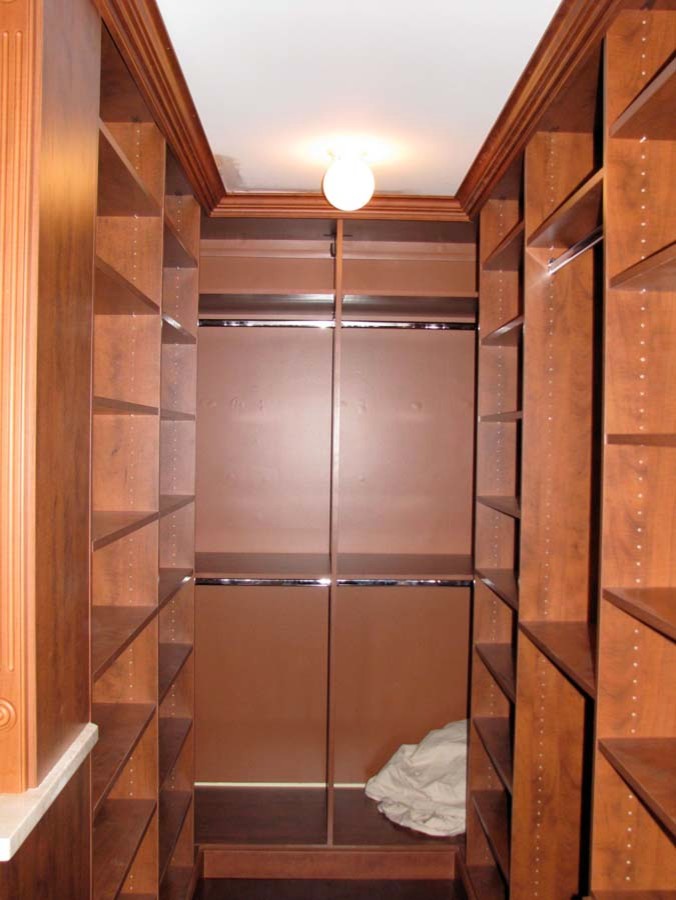 Foto de armario vestidor unisex clásico grande con puertas de armario de madera oscura