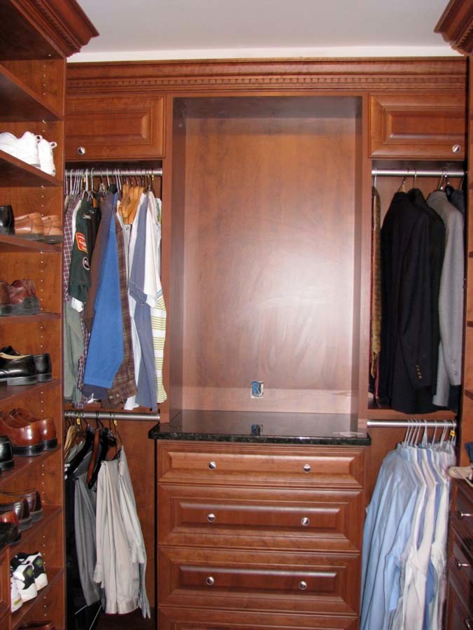 Inspiration for a large classic gender neutral walk-in wardrobe in New York with medium wood cabinets.
