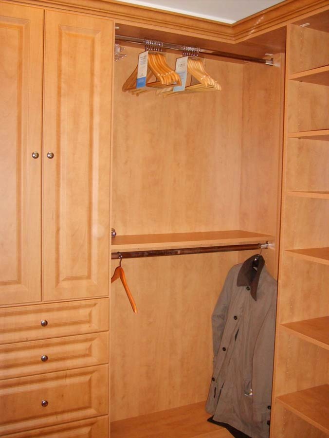 Diseño de armario vestidor unisex tradicional grande con puertas de armario de madera oscura