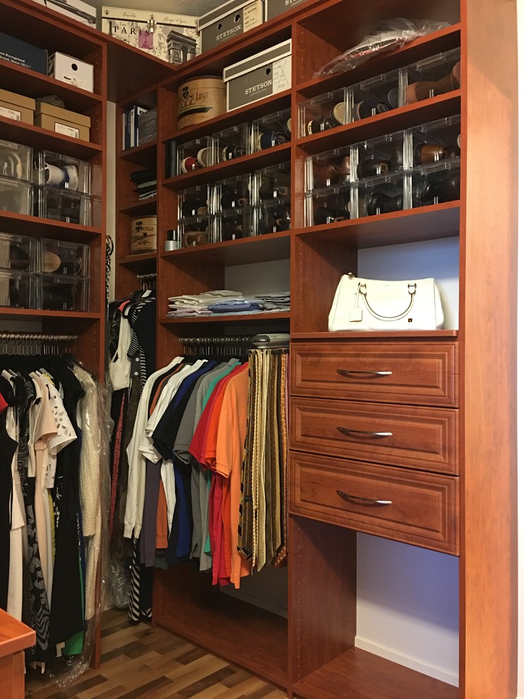 Foto de armario vestidor unisex tradicional de tamaño medio con armarios con paneles con relieve, puertas de armario de madera oscura y suelo de madera en tonos medios