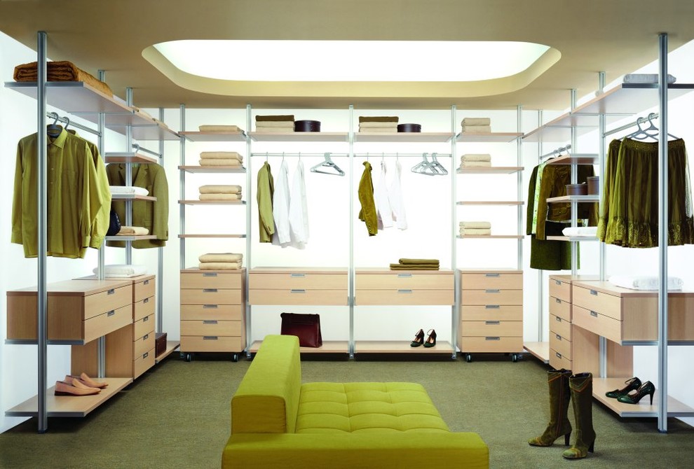 This is an example of a large contemporary gender neutral dressing room in Toronto with open cabinets, light wood cabinets, carpet and green floors.