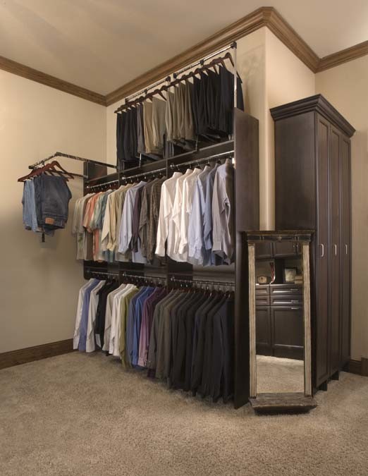 Medium sized classic gender neutral walk-in wardrobe in Denver with recessed-panel cabinets, dark wood cabinets and carpet.