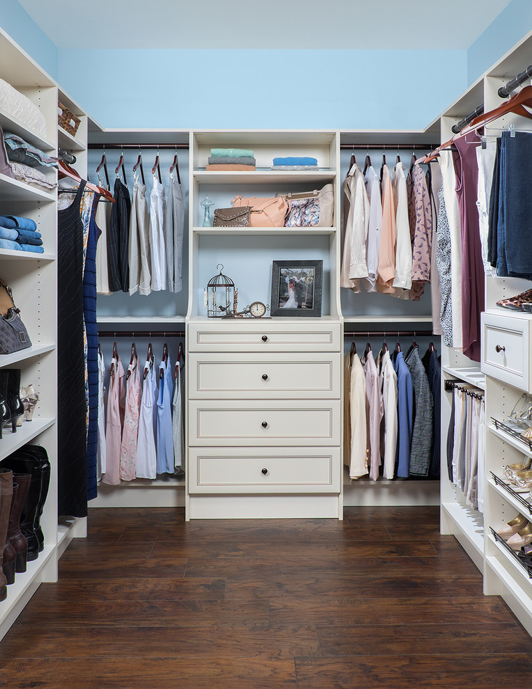 Foto de armario vestidor unisex tradicional de tamaño medio con puertas de armario blancas, suelo de madera en tonos medios y armarios abiertos