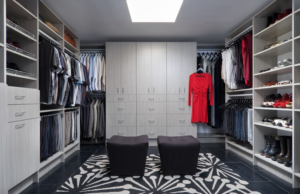 Réalisation d'un grand dressing room minimaliste en bois clair neutre avec un placard à porte plane, un sol en carrelage de porcelaine et un sol noir.