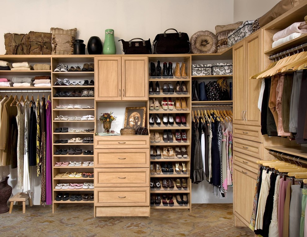 Modelo de vestidor unisex clásico grande con armarios con paneles empotrados, puertas de armario de madera clara, moqueta y suelo beige
