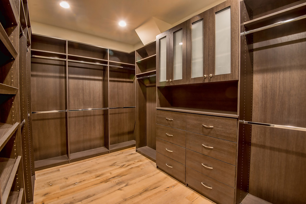 Foto di una cabina armadio unisex minimal di medie dimensioni con ante lisce, ante in legno scuro e parquet chiaro