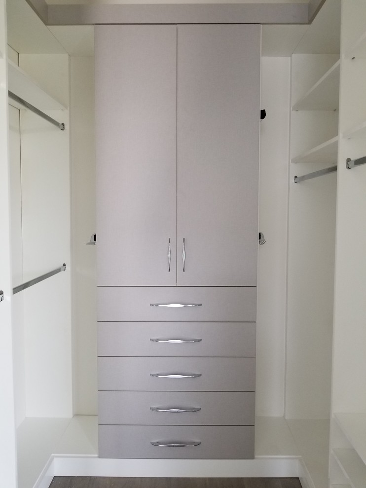 Photo of a medium sized contemporary gender neutral walk-in wardrobe in Miami with flat-panel cabinets.