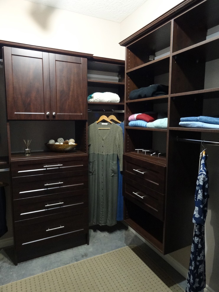 Inspiration for a medium sized traditional walk-in wardrobe in Vancouver with flat-panel cabinets, medium wood cabinets and carpet.