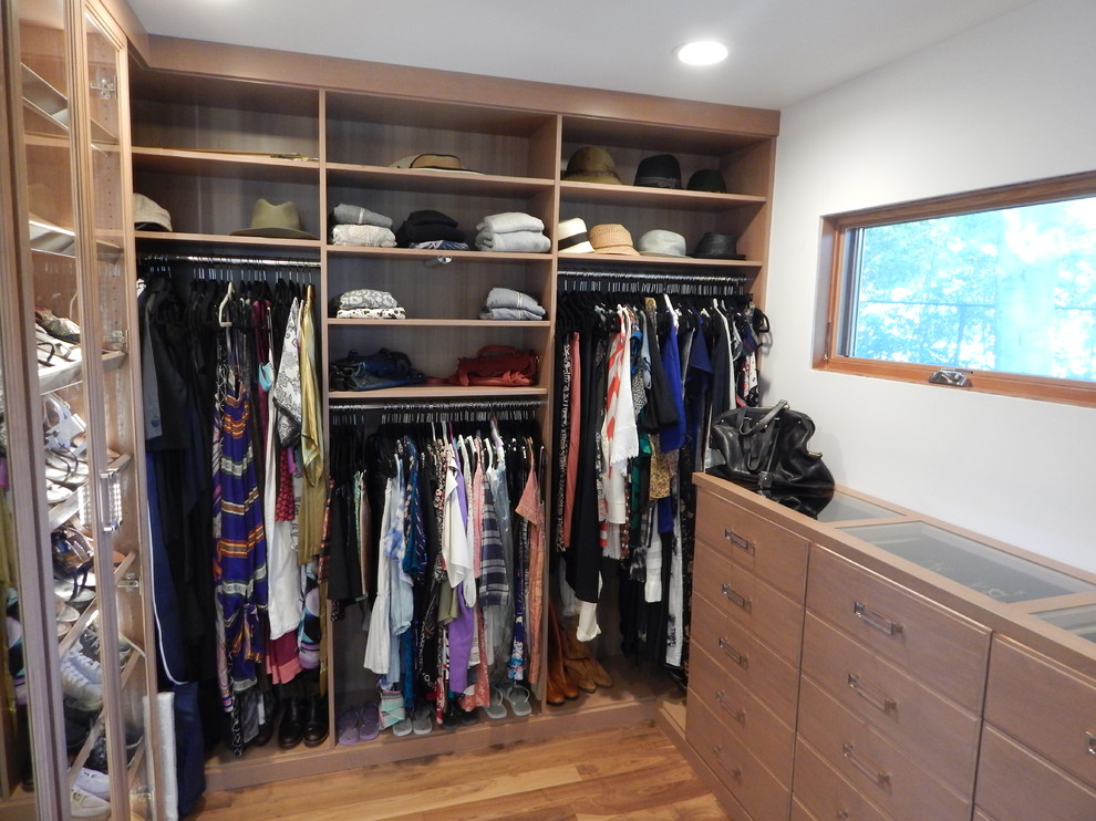 Photo of a medium sized contemporary walk-in wardrobe for women in Los Angeles with medium wood cabinets, medium hardwood flooring and brown floors.