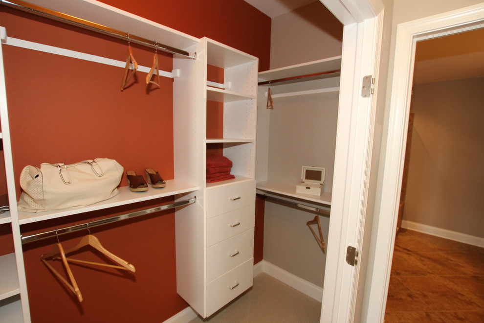 Immagine di una piccola cabina armadio unisex con ante lisce, ante bianche e moquette