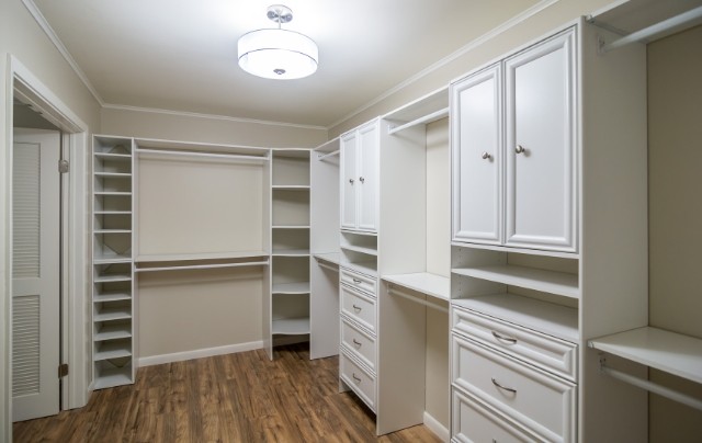 Diseño de armario vestidor unisex clásico renovado con puertas de armario blancas y suelo laminado