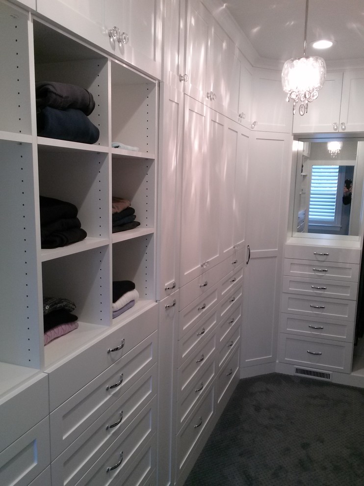 Modelo de armario vestidor unisex clásico renovado de tamaño medio con armarios estilo shaker, puertas de armario blancas y suelo de madera en tonos medios