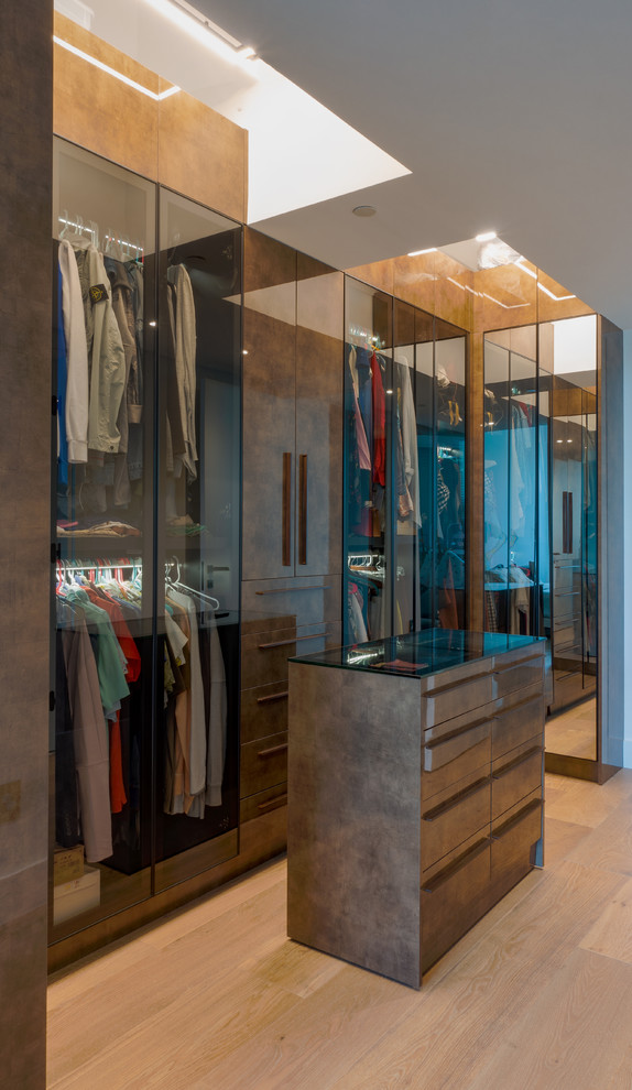 Inspiration for a large modern gender neutral walk-in wardrobe in Miami with glass-front cabinets and brown cabinets.