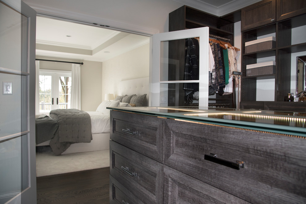 Example of a mid-sized transitional gender-neutral dark wood floor and brown floor walk-in closet design in Chicago with recessed-panel cabinets and distressed cabinets