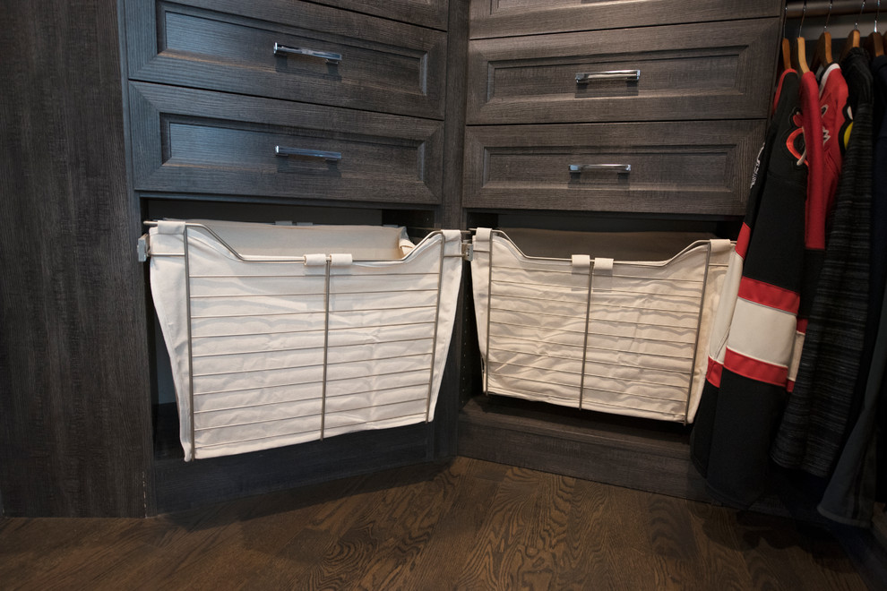 Klassisk inredning av ett mellanstort walk-in-closet för könsneutrala, med luckor med infälld panel, skåp i slitet trä, mörkt trägolv och brunt golv
