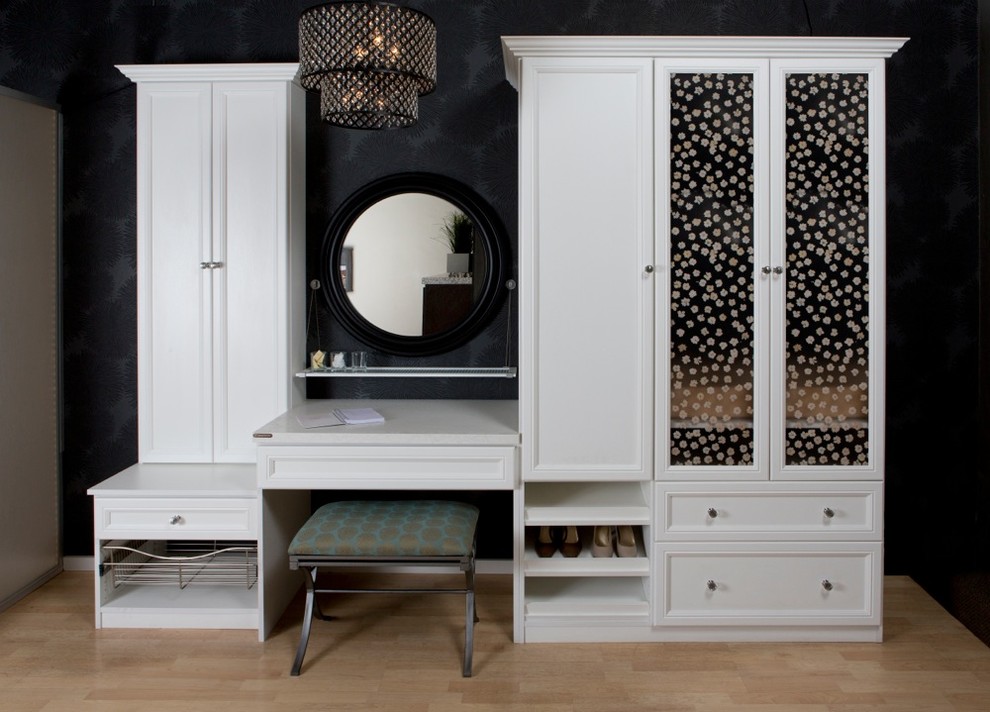 Imagen de vestidor de mujer retro de tamaño medio con armarios con rebordes decorativos, puertas de armario blancas, suelo de madera clara y suelo beige