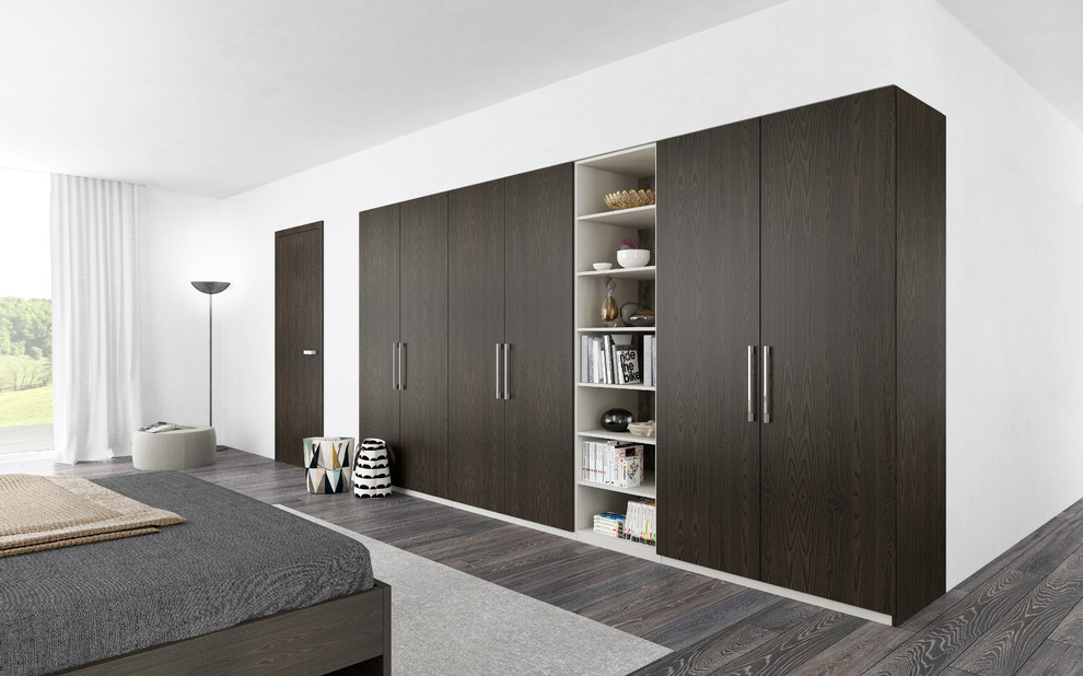 Foto di un armadio o armadio a muro minimalista di medie dimensioni con ante lisce e ante in legno bruno